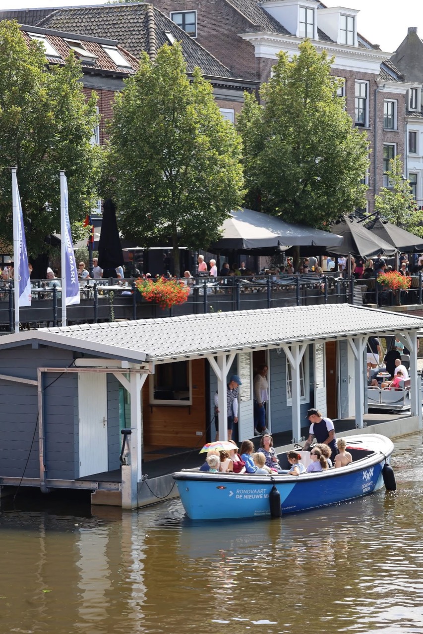 Visitors boarding the open blue boat tour sloop