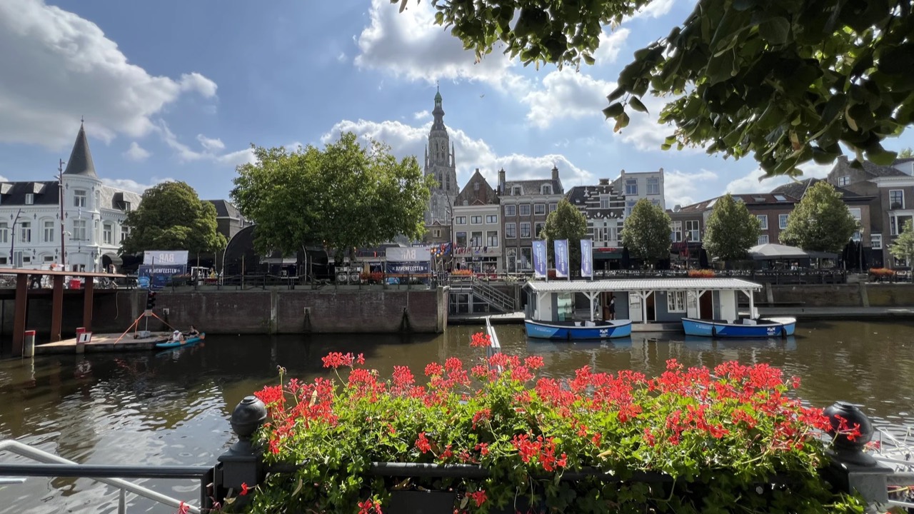 Breda harbour with the boat tour vessels, flags and the Grote Kerk in the background